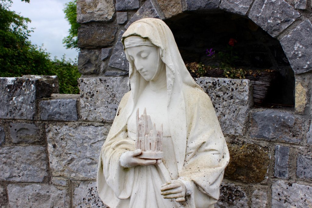 Today, St. Brigid is usually shown wearing a more modern nun's habit and holding a small model of St. Brigid's Cathedral in Kildare. Image from St. Brigid's Well, Drum, County Roscommon.