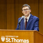 Peter Greg speaking on podium