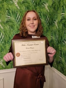 A student holding her award certificate