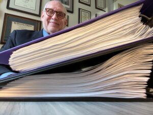 Prof. Vandegrift behind a pile of binders