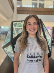 A female student in front of an art piece in Schoenecker Center