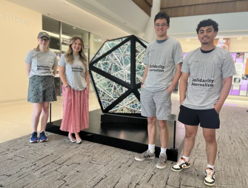 a group of students in front of an art piece