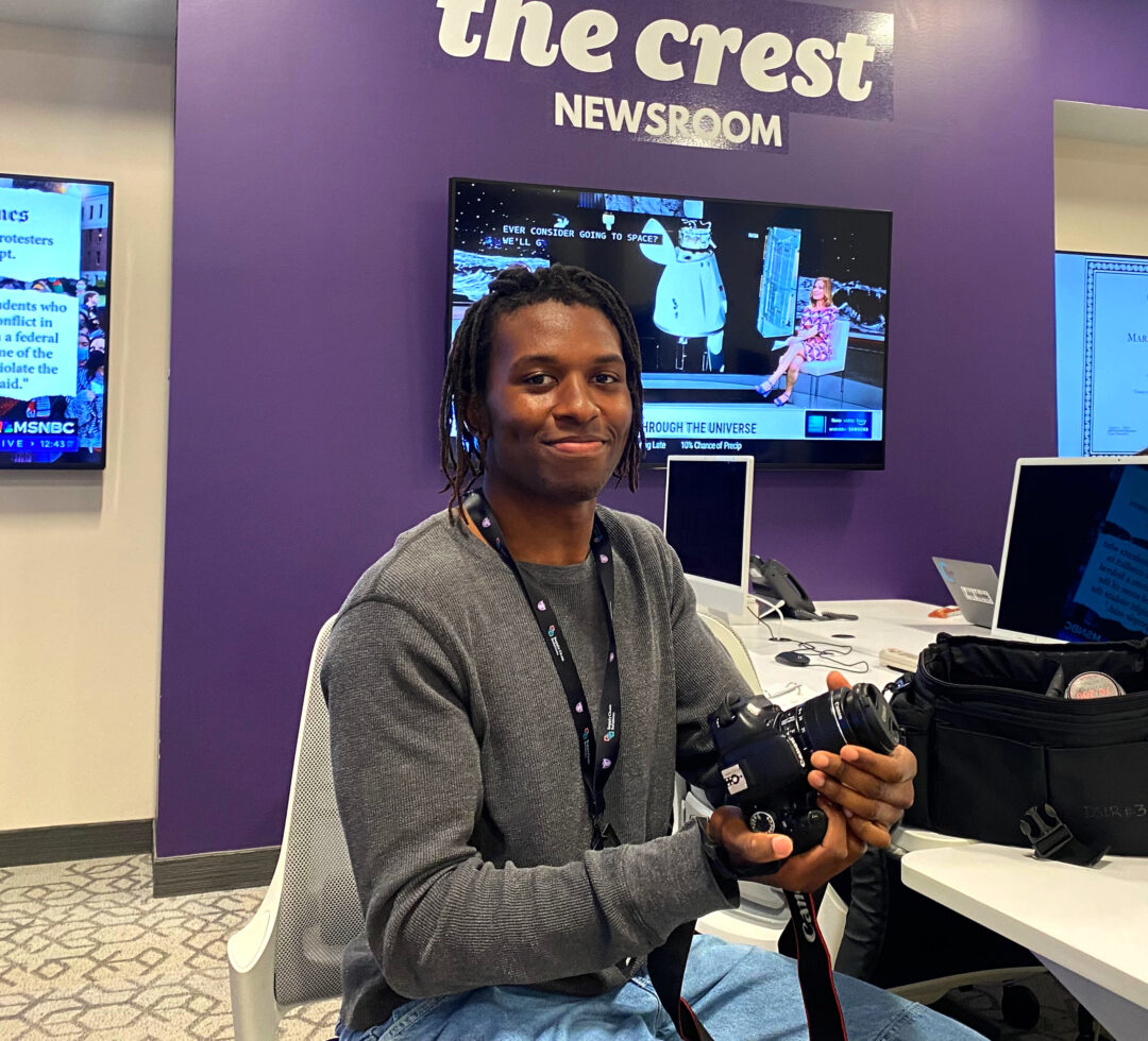 A student sitting at a desk in the Crest Newsroom