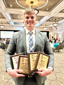 Adam Muller holding award plaques