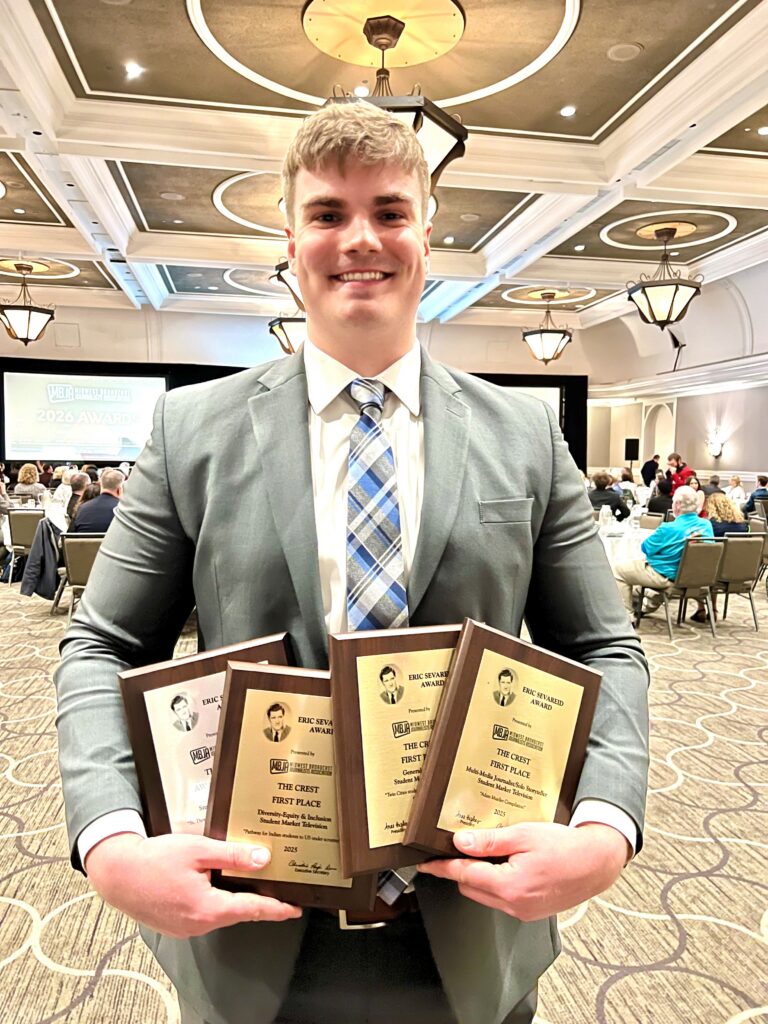 Adam Muller holding award plaques