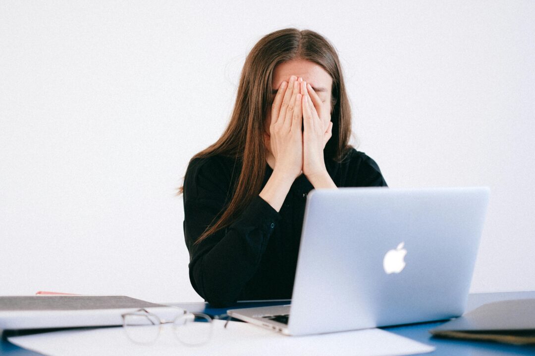 A stressed-out woman at a laptop.