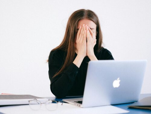 A stressed-out woman at a laptop.