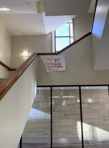 photo of library stairwell with poster reading "Did you acknowledge your privilege today?"