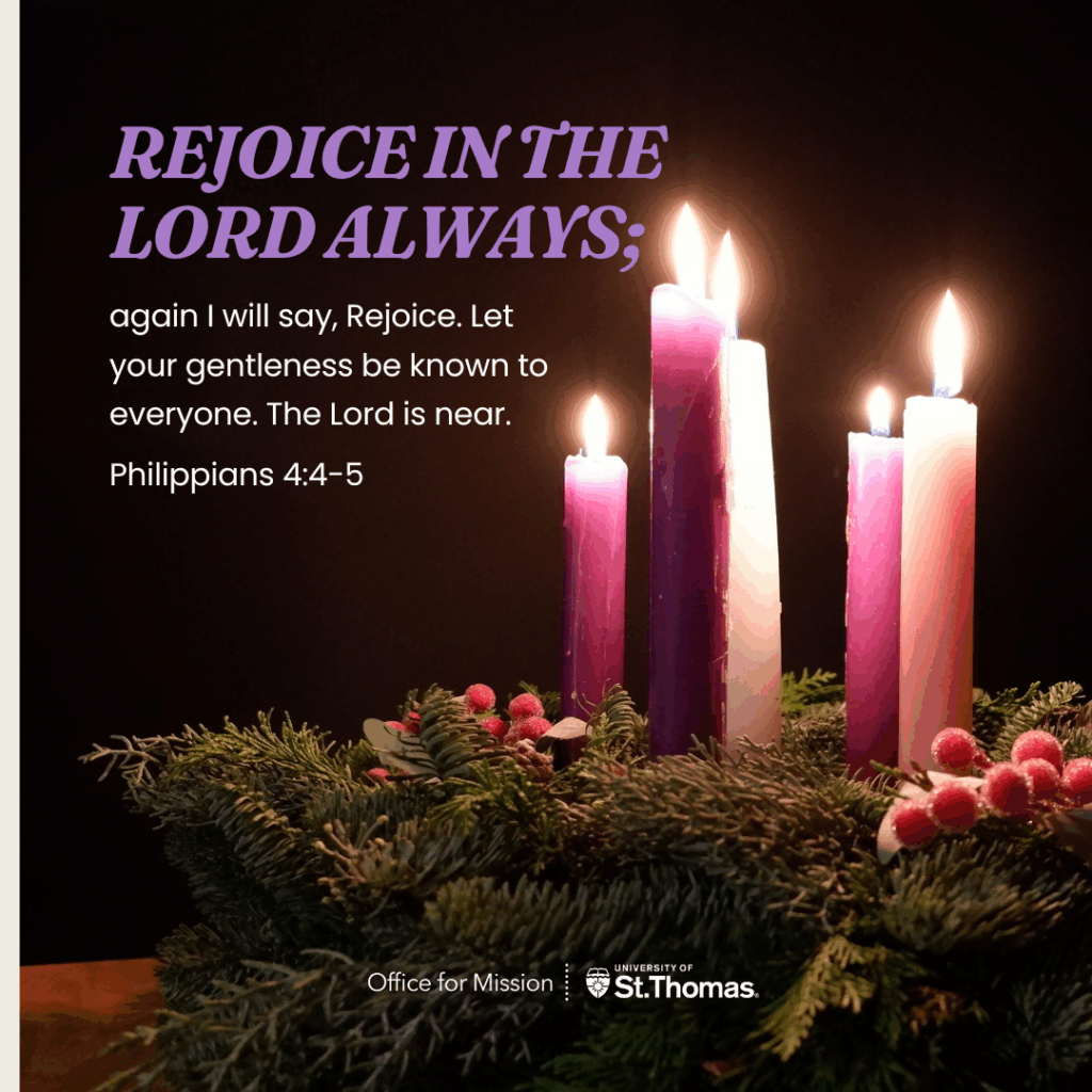 Advent wreath with evergreen branches and pink berries holding four candles—three purple and one pink. Three of the candles are lit. To the left, text reads “Rejoice in the Lord always; again I will say, Rejoice…” from Philippians 4:4–5. University of St. Thomas Office for Mission logo appears at the bottom.