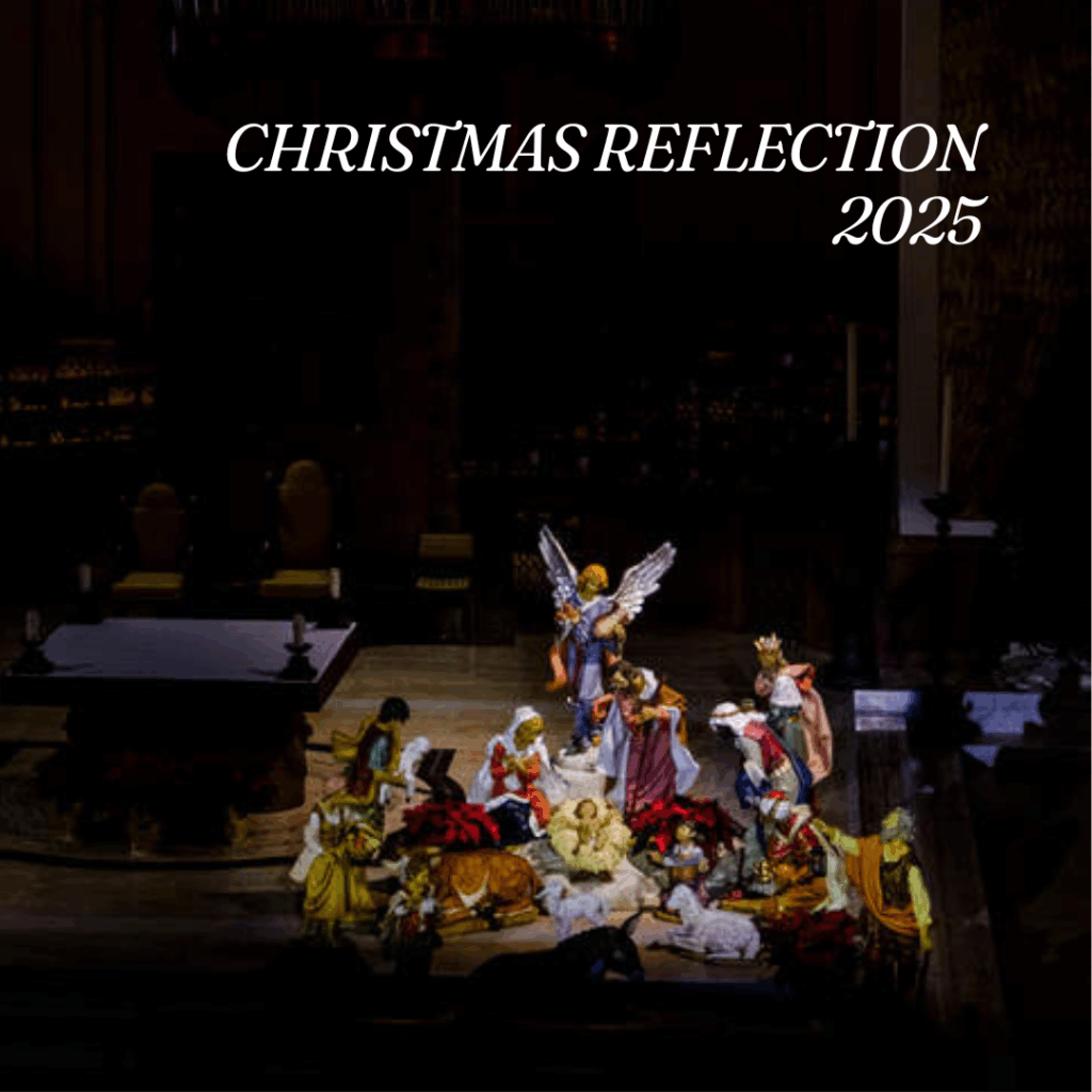 A wide-angle view of a full Nativity display inside a dimly lit church. Multiple figurines—Mary, Joseph, shepherds, angels, and animals—surround baby Jesus. The altar and sanctuary appear in the background. Text at the top reads “Christmas Reflection 2025.”